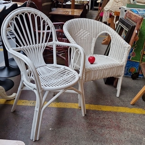 489 - Pair of white wicker chairs featuring classic woven designs.