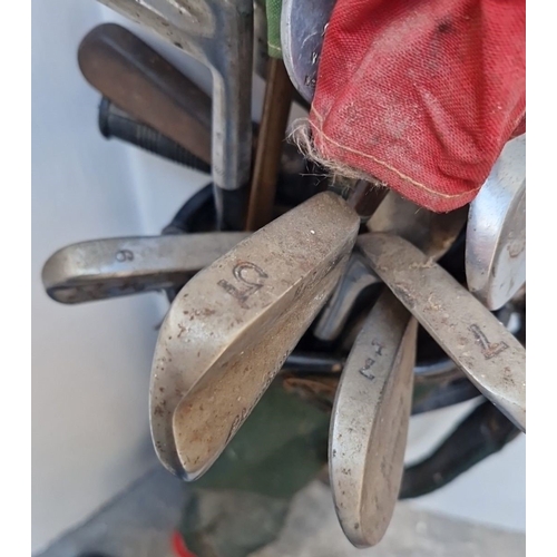 500 - Vintage golf set featuring period leather golf bag, assorted steel-shafted clubs, and retro fabric h... 