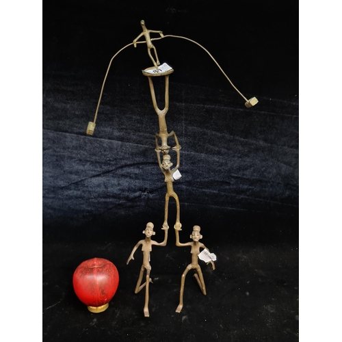 181 - A wonderful African bronze kinetic sculpture depicting a balancing trapeze act. It free stands and t... 