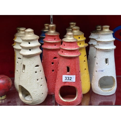 332 - A collection of 10 tea light holders in the forms of light houses. Painted in red, beige, yellow and... 