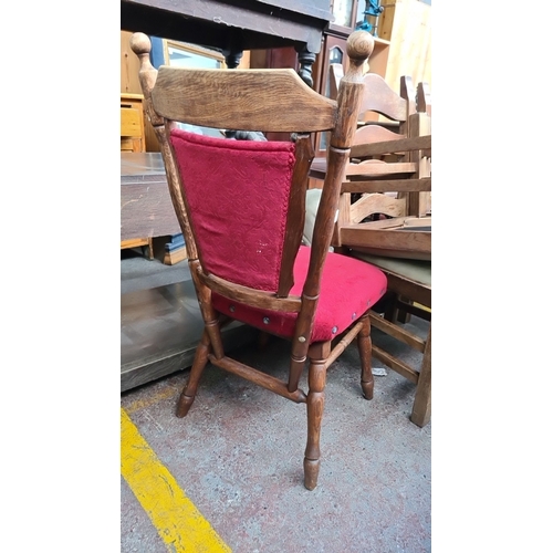 644 - Oak chair with red damask upholstery, carved crest emblem, and decorative stud detailing.