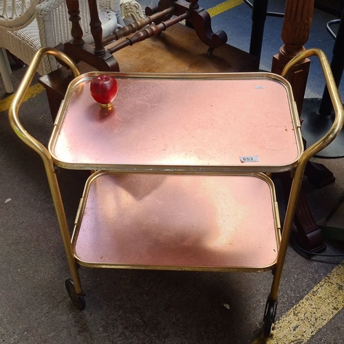 653 - Mid-century brass tea trolley with pink perforated metal trays and rolling casters. Approximate dime... 