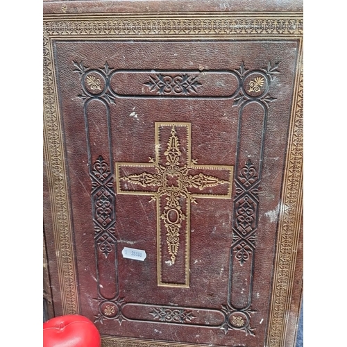 696 - A large Antique 19th-Century Leather-Bound Holy Bible features an embossed gilt cross motif, detaile... 