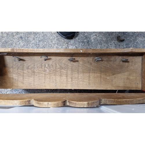 955 - Rustic wooden wall-mounted rack with scalloped top edge and integrated hooks. It has a warm, aged pa... 