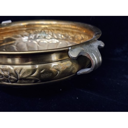 290 - A polished brass planter with floral border.