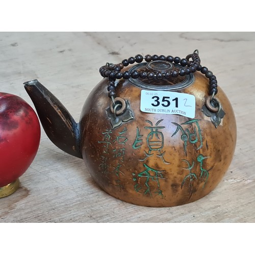 351 - A pair of Chinese teapots including an unusual wooden example with two beaded handles and a metal in... 