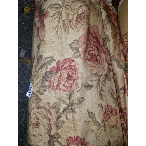 1035 - Three items. Includes two rolls of fabric. Features floral prints. Along with a vintage cushion. All... 