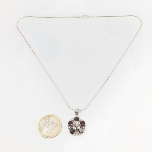 303 - A pretty sterling silver floral pendant gem set garnet necklace. Stamped 925. Weight - 10.9 grams.