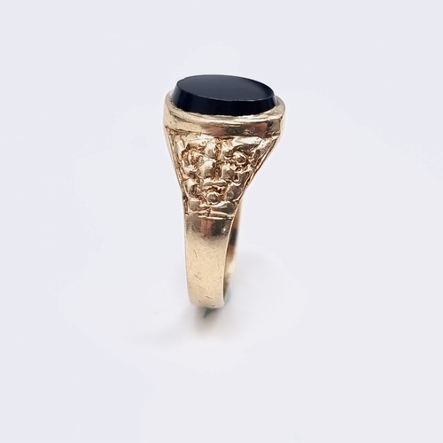 575 - Star Lot : A gents nine carat gold onyx stone signet ring set with wide shoulder mount. Ring size - ... 