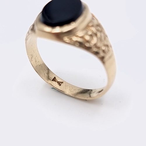 575 - Star Lot : A gents nine carat gold onyx stone signet ring set with wide shoulder mount. Ring size - ... 