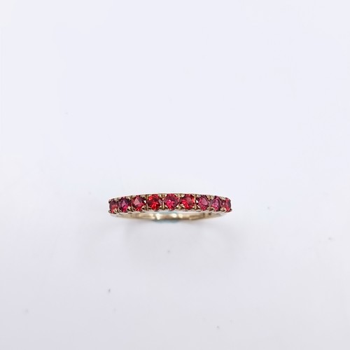 583 - Star Lot : A nine carat gold half eternity ruby ring. Size - O. Weight - 1.27 grams. Boxed.