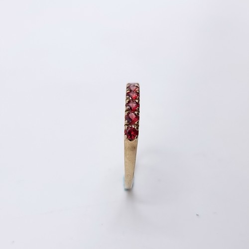 583 - Star Lot : A nine carat gold half eternity ruby ring. Size - O. Weight - 1.27 grams. Boxed.