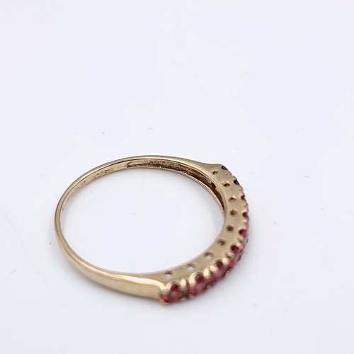 583 - Star Lot : A nine carat gold half eternity ruby ring. Size - O. Weight - 1.27 grams. Boxed.