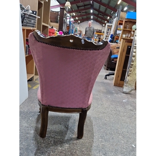 1426 - Antique Victorian-style chair with a carved wooden frame and pink upholstered button-tufted seat fea... 