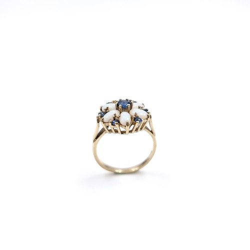 8 - Star Lot : A very attractive daisy style nine carat gold ring set with sapphire & opal surround. Siz... 