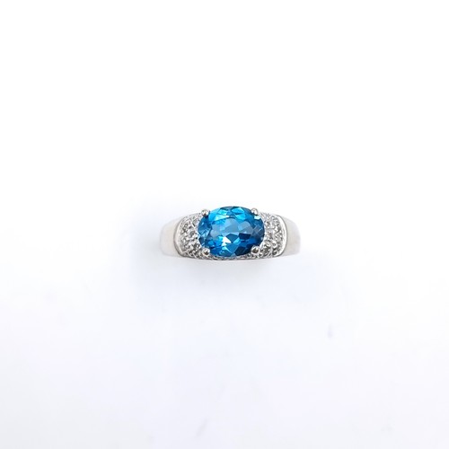 11 - Star Lot : A nine carat white gold blue topaz ring with a diamond surround. Size - K. Weight - 3.15 ... 