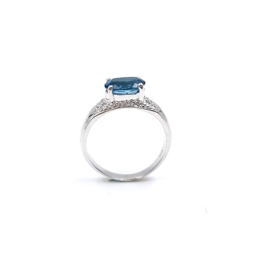 11 - Star Lot : A nine carat white gold blue topaz ring with a diamond surround. Size - K. Weight - 3.15 ... 