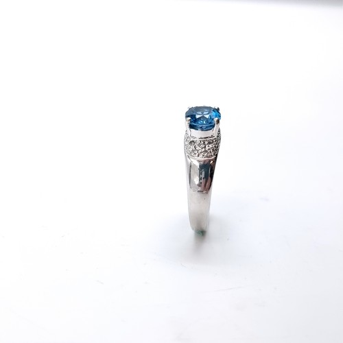 11 - Star Lot : A nine carat white gold blue topaz ring with a diamond surround. Size - K. Weight - 3.15 ... 