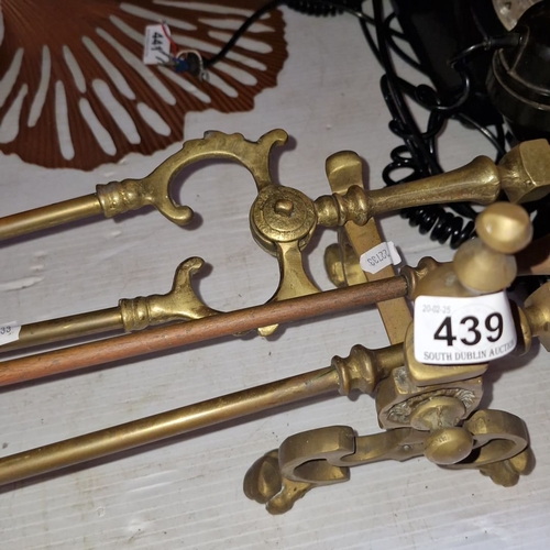 439 - A solid brass Victorian fireside companion set includes a poker, tongs, shovel, and firedogs.