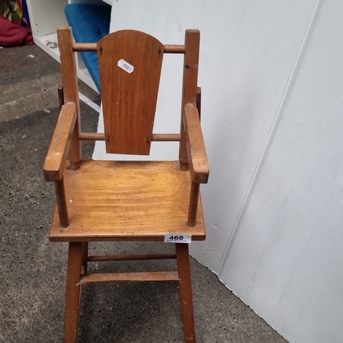 468 - A vintage wooden doll’s high chair, made from solid wood with a classic spindle-back design and remo... 