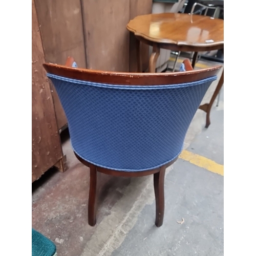 496 - A very handsome barrel-back armchair with mahogany frame and blue upholstered seat features a curved... 