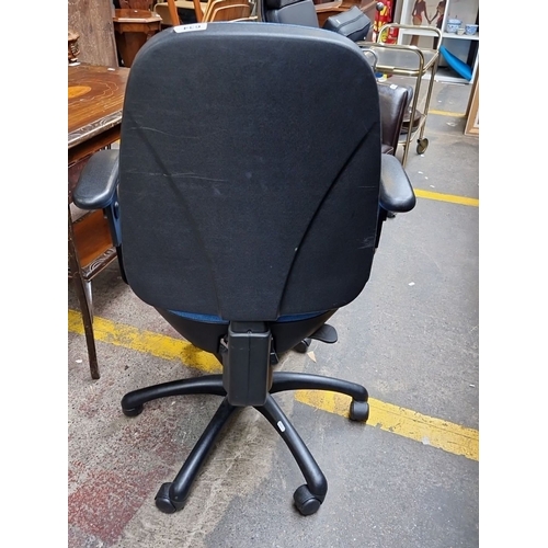 634 - Office chair with blue upholstered seat and backrest, black armrests, and a sturdy five-star wheeled... 