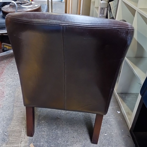 635 - Brown leather tub chair with stitched detailing and sturdy wooden legs.