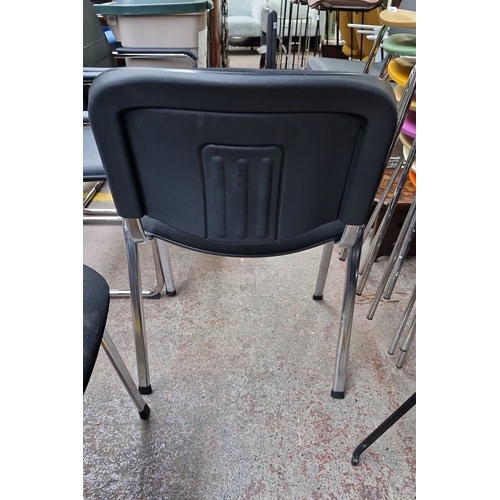 647 - Modern black office chair with chrome legs, padded seat, and durable plastic backrest. Stackable for... 