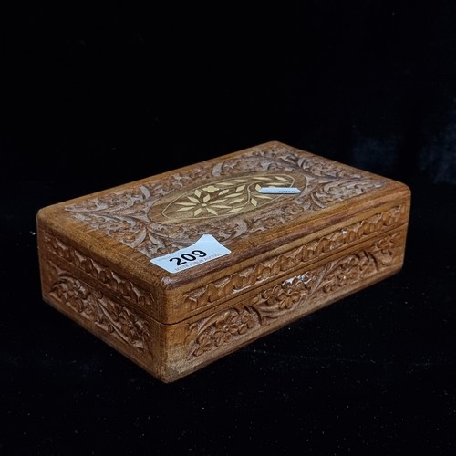 209 - An intricately carved wooden box containing unchecked coinage.