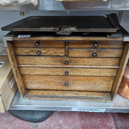 911 - Star Lot : A 1920's oak collectors chest featuring seven drawers and turned handles.