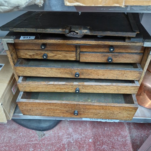 911 - Star Lot : A 1920's oak collectors chest featuring seven drawers and turned handles.