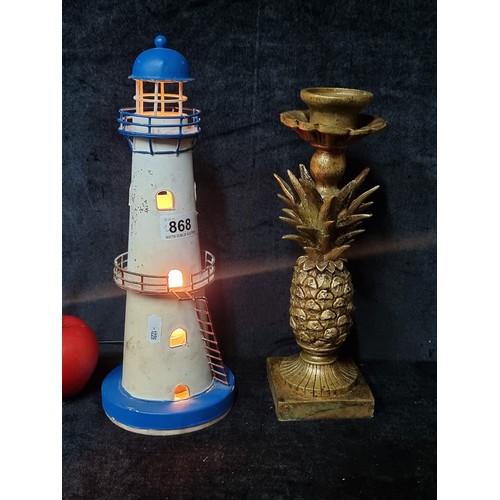 868 - A metal lighthouse table tamp along with a gilt pineapple candlestick.