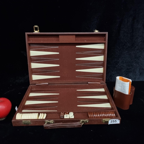 255 - A travel cased Backgammon board with dice, shakers and rule book.