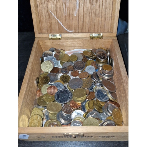 632 - Wooden cigar box filled with assorted coins and a leather coin purse.