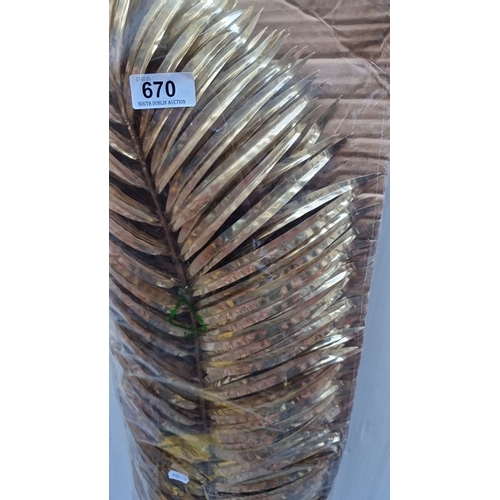 670 - Large decorative gold-tone metal palm leaf, intricately designed with a textured finish.