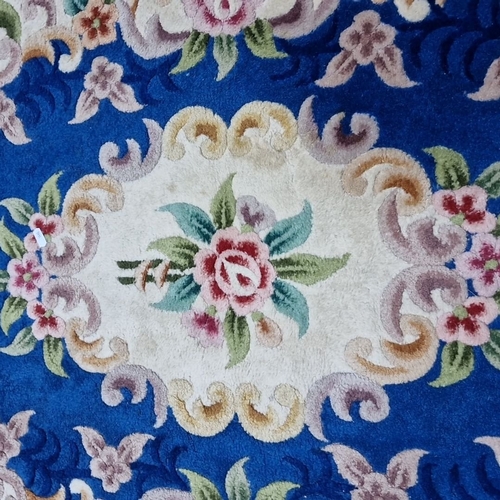 671 - Oval wool Aubusson-style rug with vibrant floral motifs on a rich blue field. Features intricate rai... 