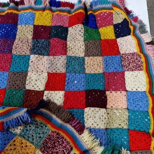 1132 - A Multicolored crochet patchwork blanket with vibrant fringe edging.