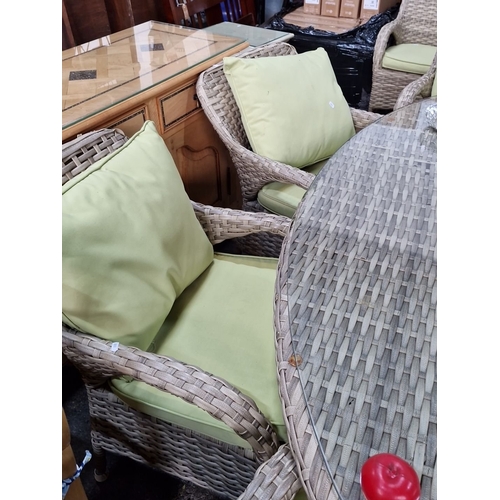 1156 - Star lot :A Wicker patio dining set includes a glass-topped oval table and six armchairs with durabl... 