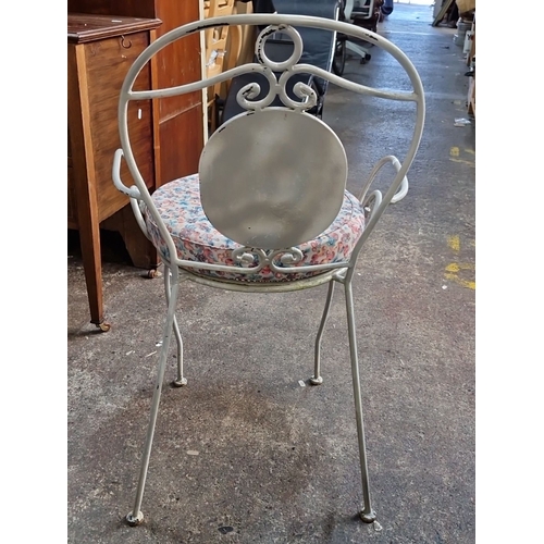 1172 - A Pair of vintage wrought iron patio chairs with mosaic tile backrests and floral upholstered cushio... 