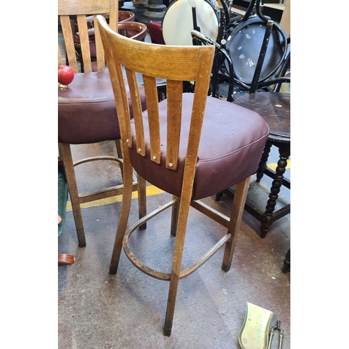 730 - Pair of tall wooden bar stools with slatted backs and brown leather upholstered thick seats.