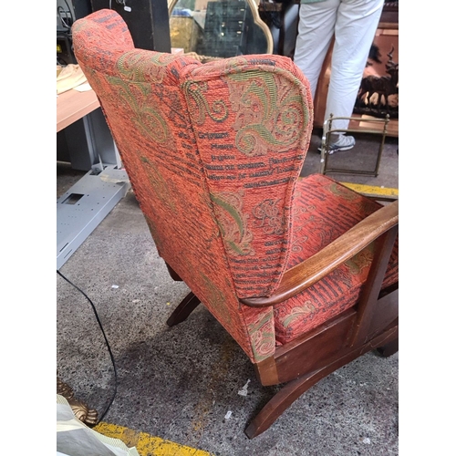 746 - A mid century Irish wooden-framed wingback rocking chair with vibrant patterned upholstery and class... 