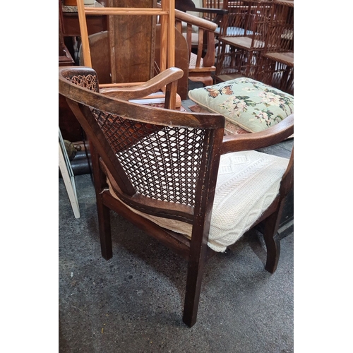 778 - Vintage wooden armchair with woven cane backrest, curved arms, and a sturdy frame. With an Arran woo... 