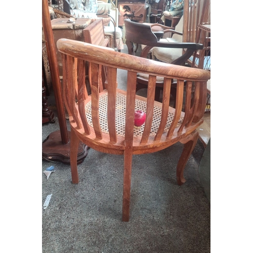 786 - Vintage wooden barrel-back chair with cane seat features a curved design, vertical slats, and cabrio... 