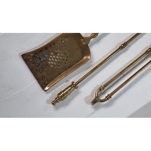 909 - Brass fireplace tool set from the Victorian era, including tongs, poker, and pierced shovel with tur... 