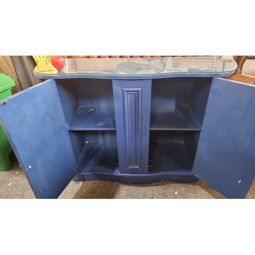 922 - Star lot :A Vintage wooden sideboard, painted deep blue with a glass top. Features curved design, do... 