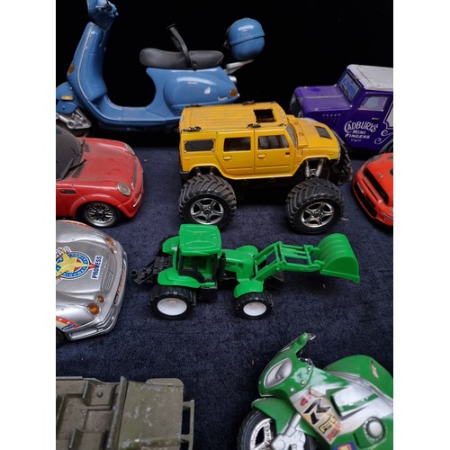 423 - Eleven toy vehicles including a Mini Cooper, Vespa motorcycle and Cadburys advertising van.