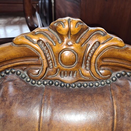 915 - Star lot :A Victorian-style button-tufted leather sofa with ornately carved wooden frame, rolled arm... 