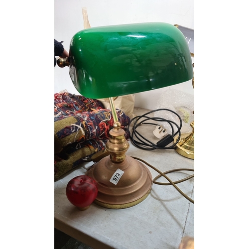 A Vintage banker’s desk lamp with brass and copper-toned base, featuring a classic green glass shade.
