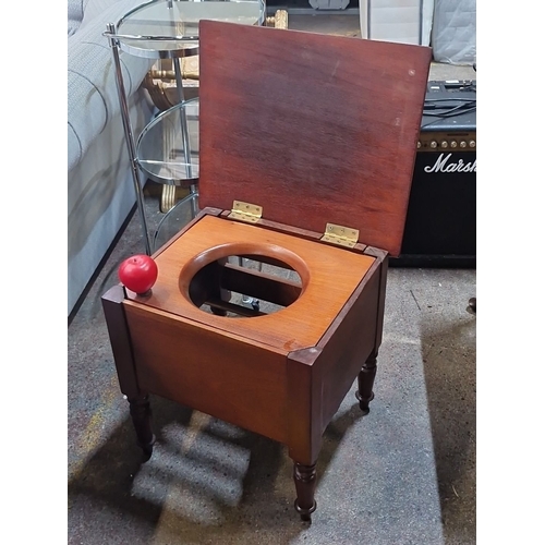 491 - A Victorian re mahogany commode, lift-top seat with brass hinges, turned legs.