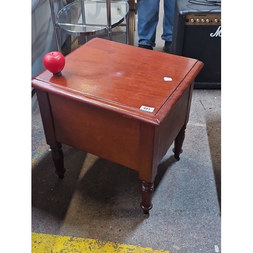 491 - A Victorian re mahogany commode, lift-top seat with brass hinges, turned legs.
